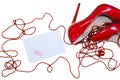 female shiny red stilettos and a card with a lipstick print on a white background