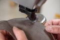 Female shoemaker hands stitching leather craft shoes on sewing machine. Artisan handmade manufacturing leather shoes