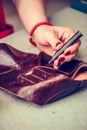 Female shoemaker working with leather using crafting tools