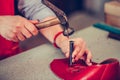 Female shoemaker working with leather using hammer and crafting tools