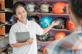 Female shop assistant holding the tablet in a hand gesture offered the helmet to male consumers