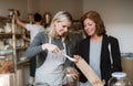 A female shop assistant serving a senior customer in a zero-waste shop.