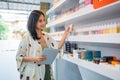 female shopkeeper smiling while checking the liquid stock at the vape store