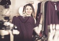Female Shopper Examining Long Sleeve Shirts In Underwear Shop