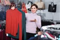 Female shopper examining turtleneck sweaters in women cloths shop Royalty Free Stock Photo