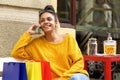 Female shopper sitting outdoors and using mobile phone