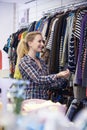 Female Shopper In Thrift Store Looking At Clothes Royalty Free Stock Photo