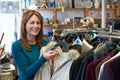 Female Shopper In Thrift Store Looking At Clothes Royalty Free Stock Photo