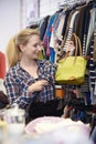 Female Shopper In Thrift Store Looking At Handbags Royalty Free Stock Photo