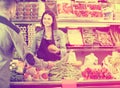 Female shopping assistant helping customer to buy fruit and vegetables in grocery shop Royalty Free Stock Photo