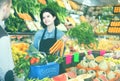 Female shopping assistant helping customer to buy fruit and vegetables in grocery shop Royalty Free Stock Photo