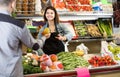 Female shopping assistant helping customer to buy fruit and vegetables in grocery shop Royalty Free Stock Photo