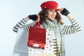 Female with shopping bags against winter light blue background Royalty Free Stock Photo