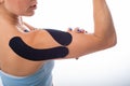 Female shoulder with kineziotape on a white background. Alternative medicine for sports injuries of joints and ligaments