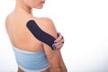 Female shoulder with kineziotape on a white background. Alternative medicine for sports injuries of joints and ligaments