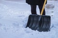 Female shovelling snow with an empty shovel, during winter.