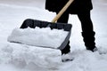 Female shovelling snow with a shovel full of snow, during winter.