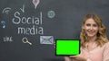 Female showing prekeyed tab standing on blackboard background using social media