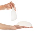 Female shows different types of breast implants in hands isolated on white background with clipping path.