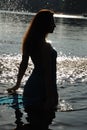 Female silhouette against shining water