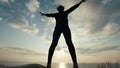 Female silhouette doing physical exercise against the sunrise