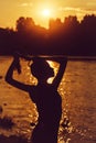 Female silhouette near water on sunset Royalty Free Stock Photo