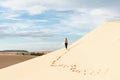 Female silhouette walking in desert sand dunes of Mui Ne, Vietnam