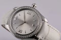 Female silver watch with a light grey dial, silver clockwise, chronograph, with a white leather strap isolated on white background Royalty Free Stock Photo