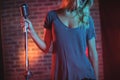 Female singer with microphone standing in nightclub