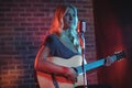 Female singer playing guitar in nightclub