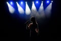 Female singer on the stage holding a microphone. Royalty Free Stock Photo