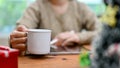 A female sipping coffee while using tablet, working at her desk at home. cropped shot