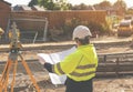 Female site engineer surveyor working with theodolite total station EDM equipment on a building construction site outdoors toned Royalty Free Stock Photo