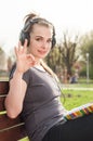 Female sitting on bench in park and show ok gesture Royalty Free Stock Photo