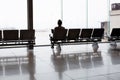 Female sitting on bench seat waiting in front of large window