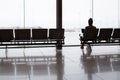 Female sitting on bench seat waiting in front of large window