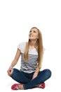 Female sitting with crossed legs on the floor looking up Royalty Free Stock Photo