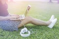 Female sitting on greed grass by relaxing and typing keyboard of