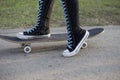 Female with skateboard in high knee sneakers.