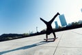 Skateboarder doing a handstand on skateboard in city