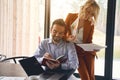 Female with sketches leaning on her male colleagues shoulder Royalty Free Stock Photo