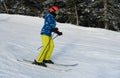 Female skier in bright outfit enjoying winter holidays skiing at Stowe Mountain Resort.