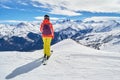 Female skier with colorful clothes looking at the Les Aiguilles d`Arves peaks, from a ski slope high above the Les Sybelles domain Royalty Free Stock Photo