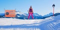 Female skier on the edge of a black ski run, looking into the distance, next to a slope sign saying Difficult Slope in Italian Royalty Free Stock Photo