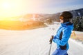 Female skier on the middle of ski slope against ski-lift Royalty Free Stock Photo