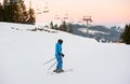 Female skier on middle of ski slope against ski lifts Royalty Free Stock Photo