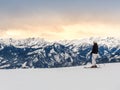 Female skier on slope against mountains and sunset in winter ski resort Zell am See in the Alps, Austria. Snowy Royalty Free Stock Photo