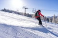 Female skiier dressed in red jacket enjoys slopes. Royalty Free Stock Photo