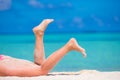 Female slim tanned legs on a white tropical beach Royalty Free Stock Photo