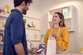 Female Small Business Owner Accepting Contactless Payment In Shop From Customer Using Mobile Phone